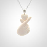This is a hand carved love heart with love fingers made from bone with sterling silver bale and provided with a sterling silver chain.